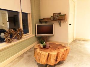 蒂尔堡The Old Garage的客厅配有树 ⁇ 咖啡桌和电视