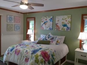 普莱瑟维尔Ponderosa Ridge A B & B的卧室配有一张床,墙上挂有绘画作品