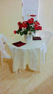 博卡奇卡Apartahotel carla的一张白色桌子,上面有红花花瓶