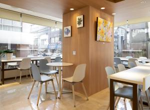 东京上野第一都市酒店的用餐室设有桌椅和窗户。