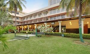 班加罗尔Royal Orchid Resort & Convention Centre, Yelahanka Bangalore的享有棕榈树酒店外部的景色