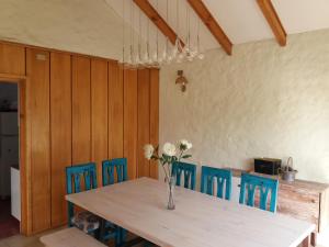 迪卡托Casa en Pingueral的一张带蓝色椅子的餐桌和鲜花花瓶