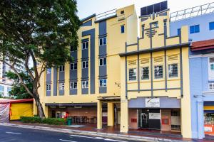 新加坡Fragrance Hotel - Rose的城市街道上的黄色建筑