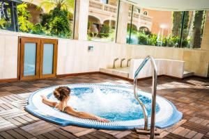 安德莱奇港芒港水疗酒店的躺在建筑物热水浴缸中的女人