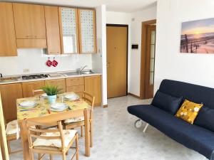 格拉多Residence Viale del Sole的客厅配有桌子和蓝色沙发
