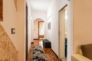 罗马梅鲁拉娜套房公寓的一条带白色墙壁的走廊和一个带凳子的楼梯