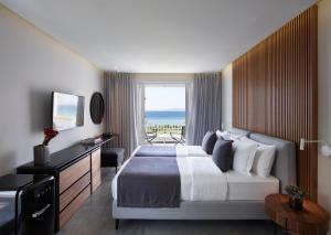 马斯蒂查里Neptune Luxury Resort的酒店客房设有一张床,享有海景。