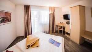 新乌尔姆伽尼城市酒店的配有一张床和一张书桌的酒店客房