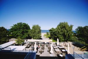 索波特Hotel Pomarańczowa Plaża ex Bursztyn的享有长椅公园和大海的景色