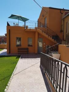 卡利亚里Casa dei Talenti的房屋设有带长凳和遮阳伞的阳台