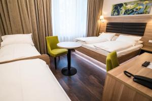 维也纳Hotel Marc Aurel - Newly refurbished的酒店客房带两张床和一张桌子以及椅子。