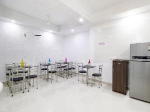 新德里Green Lotus Residency Dwarka的一间带桌椅和冰箱的用餐室