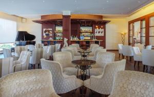 卡兰博希La Quinta Menorca by PortBlue Boutique - Adults Only的一间设有白色椅子的餐厅和一间酒吧