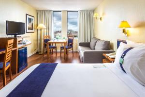 里斯本Holiday Inn Lisbon, an IHG Hotel的酒店客房设有床和客厅。