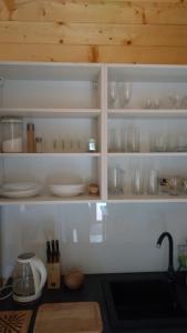 科乌切沃Domki pod orzechem的一个带餐具和玻璃杯的厨房架