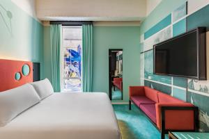 鹿特丹布鲁诺室友酒店 的一间卧室配有一张床、一张沙发和一台电视。