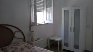 奥尼纳Casa Mare Ognina的一间卧室设有一张床、一个窗口和一把椅子