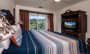 赫拉多拉Ocean View Condo in Los Sueños的一间卧室配有一张床,并在一间客房内配有电视。