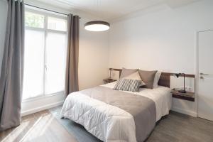 巴黎Les cles du 27 Paris的白色的卧室设有床和窗户