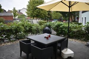 吕丁豪森My Home - Ferienwohnung的庭院内桌椅和遮阳伞