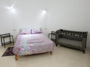米多恩Menzel Rayan的一间卧室配有一张带粉色床单和婴儿床的床。