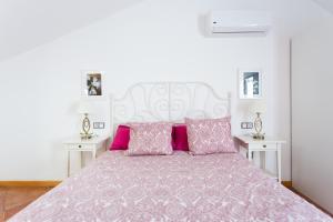 帕莱索海滩EDEN RENTALS Duplex Adeje Palace的卧室配有一张带粉红色枕头的大床