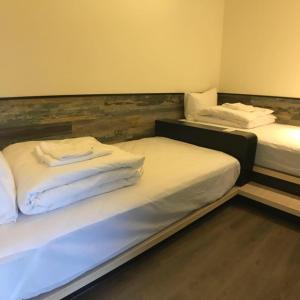 马公热带鱼民宿 的配有白色床单的客房内的两张床