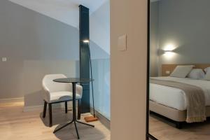 马德里马德里市中心MH公寓式酒店的卧室配有1张床、1张桌子和1把椅子