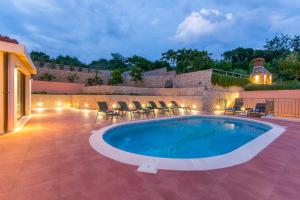 莫鲁纳特Villa Molunat的一个带椅子的游泳池和一个庭院