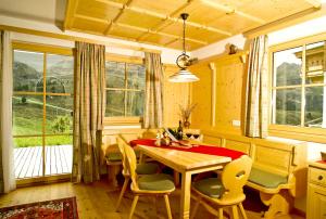库哈台Alpenchalets - Obholzer的一间带桌椅和窗户的用餐室