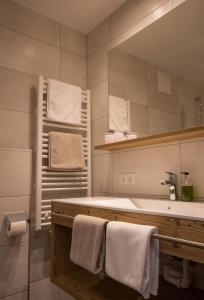 圣安东阿尔贝格Haus Sattelblick的浴室配有盥洗盆、镜子和毛巾