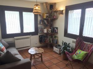 陶尔Hostal Rural Sant Climent的带沙发、椅子和窗户的客厅