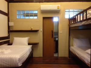 慕斯考艾Treasure Inn Khaoyai的一间设有两张床的客房和一个带门的走廊