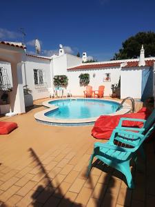 阿尔布费拉Villa Quica, heated pool的一个带游泳池和蓝椅的庭院