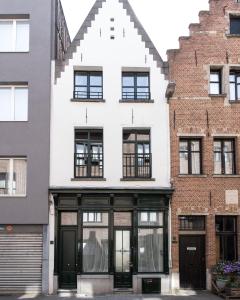安特卫普Boutique Holiday Home ZaligInAntwerpen 77的白色的建筑,设有黑色的大门和窗户