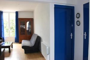 鲁瓦扬Tout A Pied Au Coeur De Royan的带沙发和蓝色门的客厅