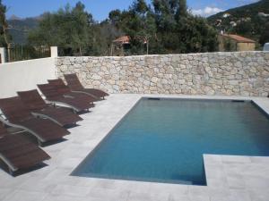 加莱里亚阿里弗酒店的一个带椅子和石墙的游泳池