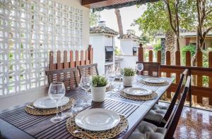 莱利亚纳El Oasis Villa Resort的阳台上配有带盘子和酒杯的木桌