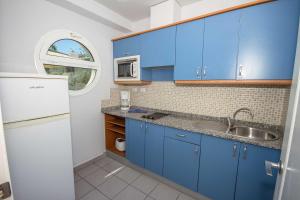 波多黎各特拉扎玛阳光套房塞瓦图尔酒店的厨房配有蓝色橱柜和水槽