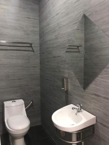 Baling巴陵山花园村木屋的浴室配有白色卫生间和盥洗盆。