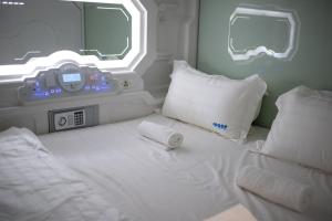 吉隆坡吉隆坡唐人街太空酒店的卧室配有白色的床,上面有时钟
