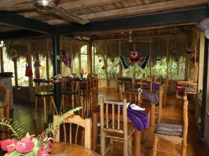 里约杜尔塞Hotel Kangaroo y Restaurante的一间在房间内配有木椅和桌子的餐厅