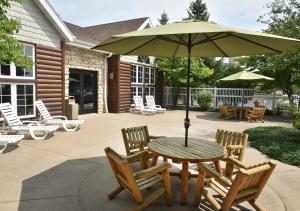 罗斯切尔德Stoney Creek Hotel Wausau - Rothschild的庭院内桌椅和遮阳伞