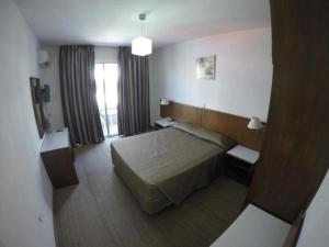 拉纳卡Les Palmiers Petrou Apartments的酒店客房设有床和窗户。
