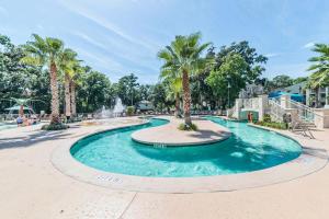 希尔顿黑德岛Coral Sands Resort by Palmera的棕榈树公园内一个带喷泉的游泳池