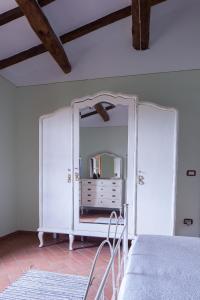 托里塔迪谢纳Podere Villa Rosa的一间带镜子的卧室和一张位于客房内的床