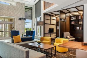 鲁兹Hyatt Place Tampa/Wesley Chapel的客厅配有黄色和蓝色的椅子和桌子