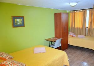 基多Hostal Terra 1 - ANDALUCÍA的客房设有两张床、一张桌子和一张书桌
