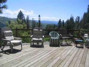 GrangevilleWhitebird Summit Lodge的甲板上摆放着三把椅子和一张桌子