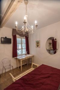 拉莫拉Villa Goccia di Vino的一间卧室配有一张床、一张桌子和一个吊灯。
